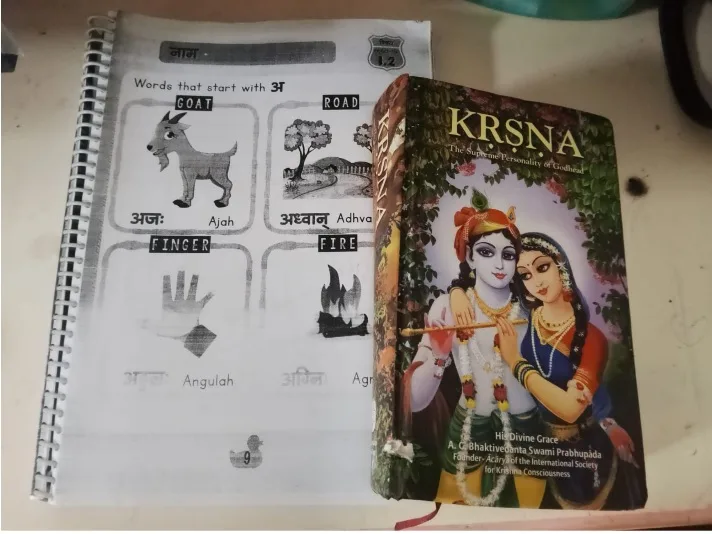 A printed Sanskrit workbook page teaching words beginning with the letter अ